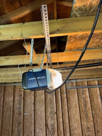 Garage door opener attached to wooden ceiling beams.