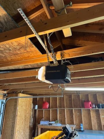 Garage door opener mounted on the ceiling in a garage.