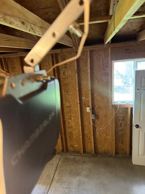 Garage ceiling and wall with a Chamberlain garage door opener and a small window.