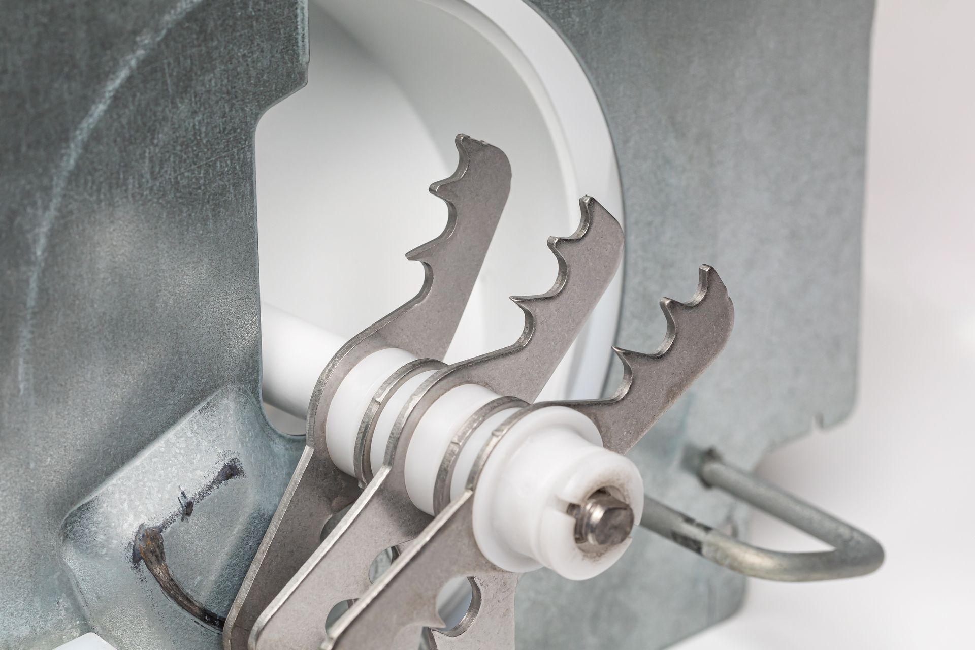 Person cleaning a washing machine filter, pointing to lint buildup inside the appliance