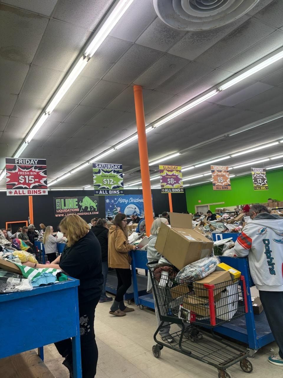 People browsing items in a brightly lit discount store with various price signs above.