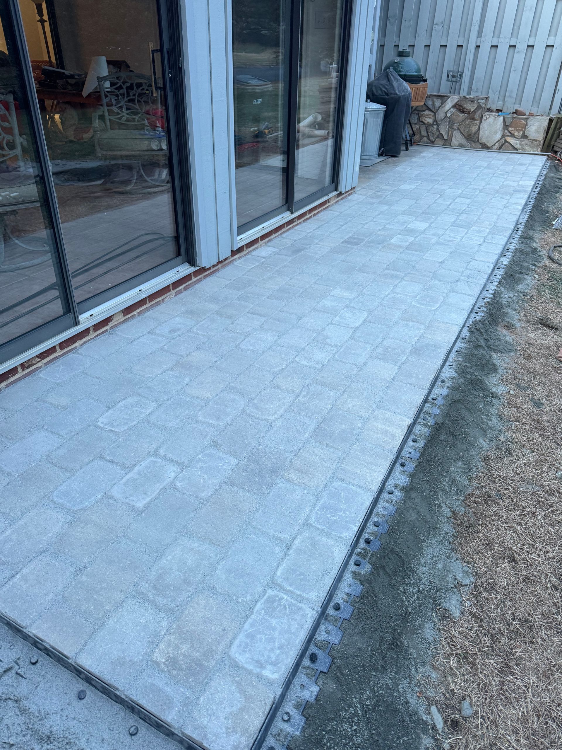 Concrete walkway beside a glass storefront, with a person crouching near the wall.