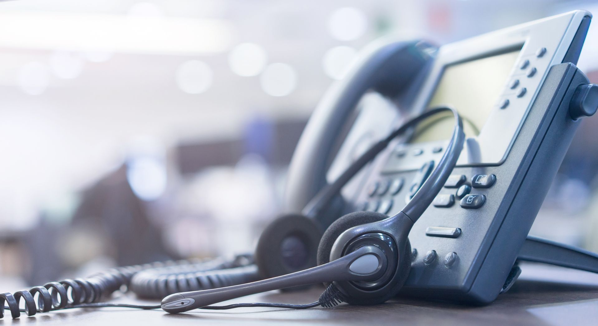 Desk phone with headset, likely in an office.