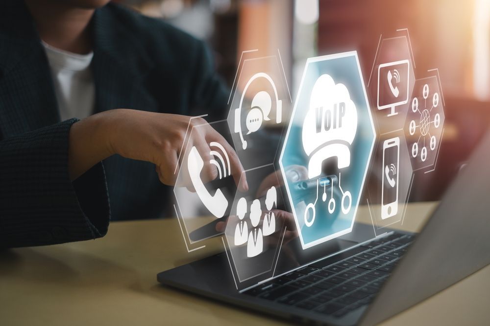 Person using a laptop with a VoIP interface overlay.