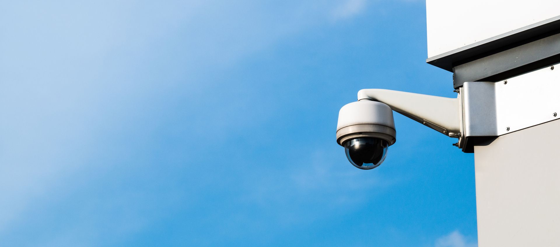 A security camera is mounted on the side of a building.