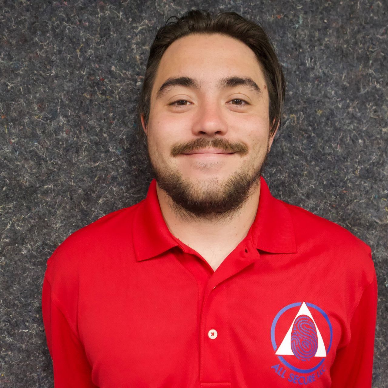 A man with a beard is wearing a red polo shirt