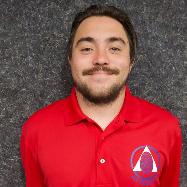 A man with a beard is wearing a red polo shirt