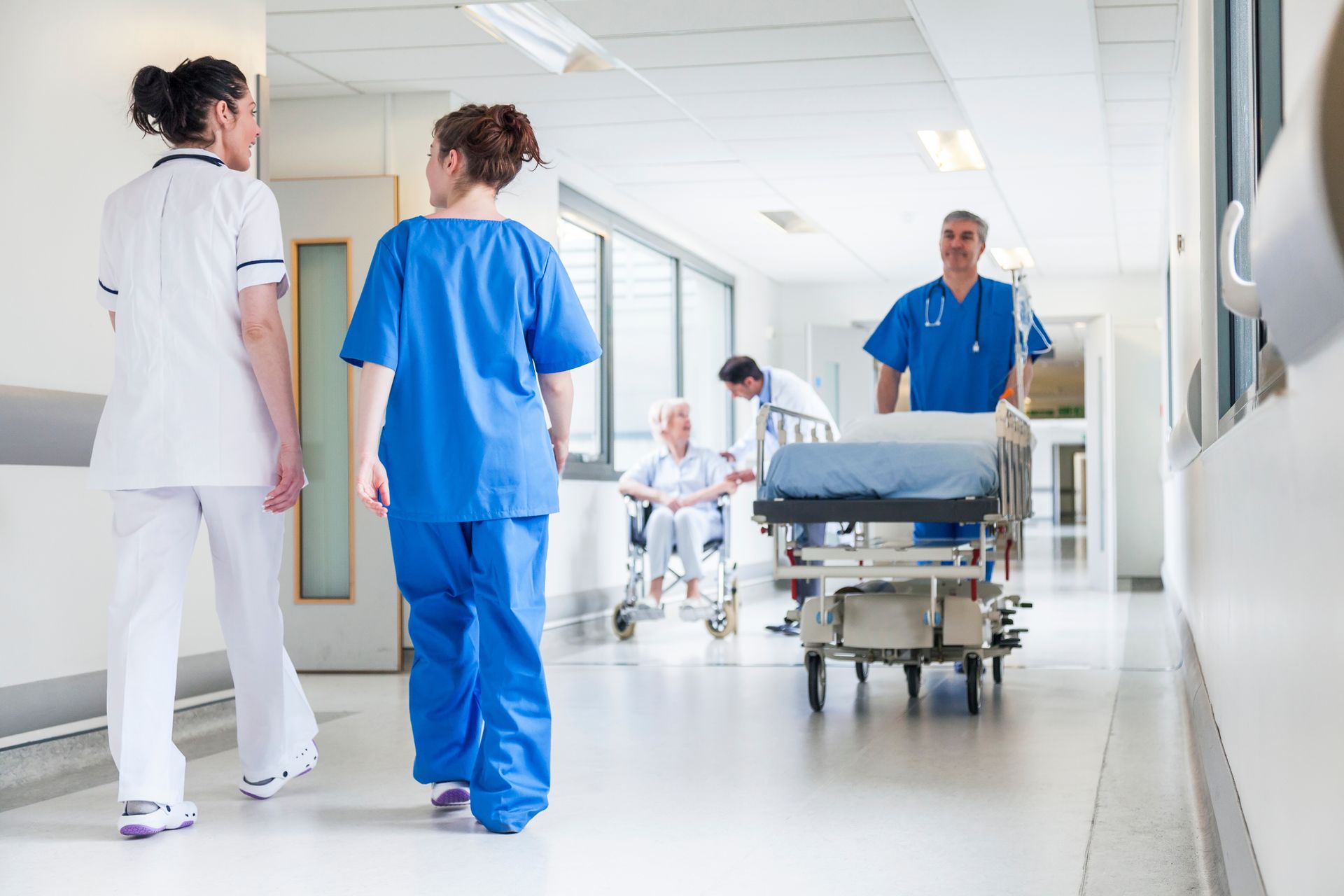 A group of nurses are walking down a hospital hallway.