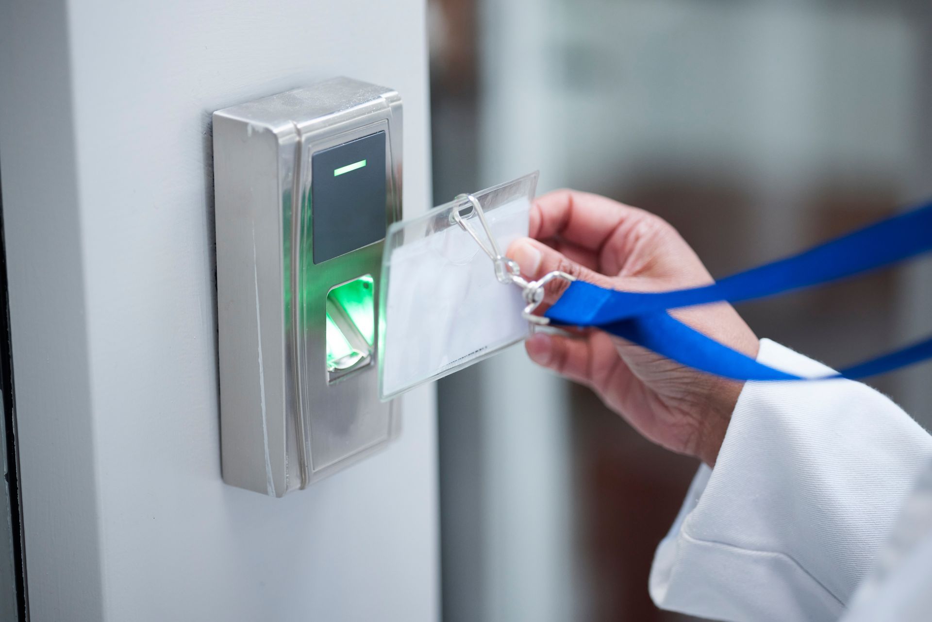 A person is using a fingerprint scanner to open a door.