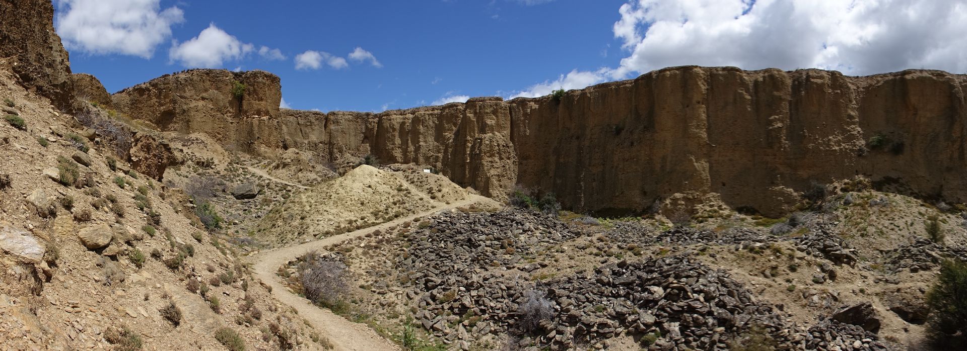 Walkers exploring the rugged terrain at Bannockburn Sluicings Walk, surrounded by remnants of gold mining