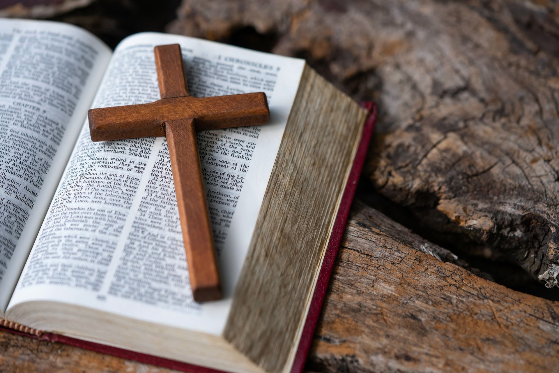Una croce di legno è posta sopra una Bibbia aperta.