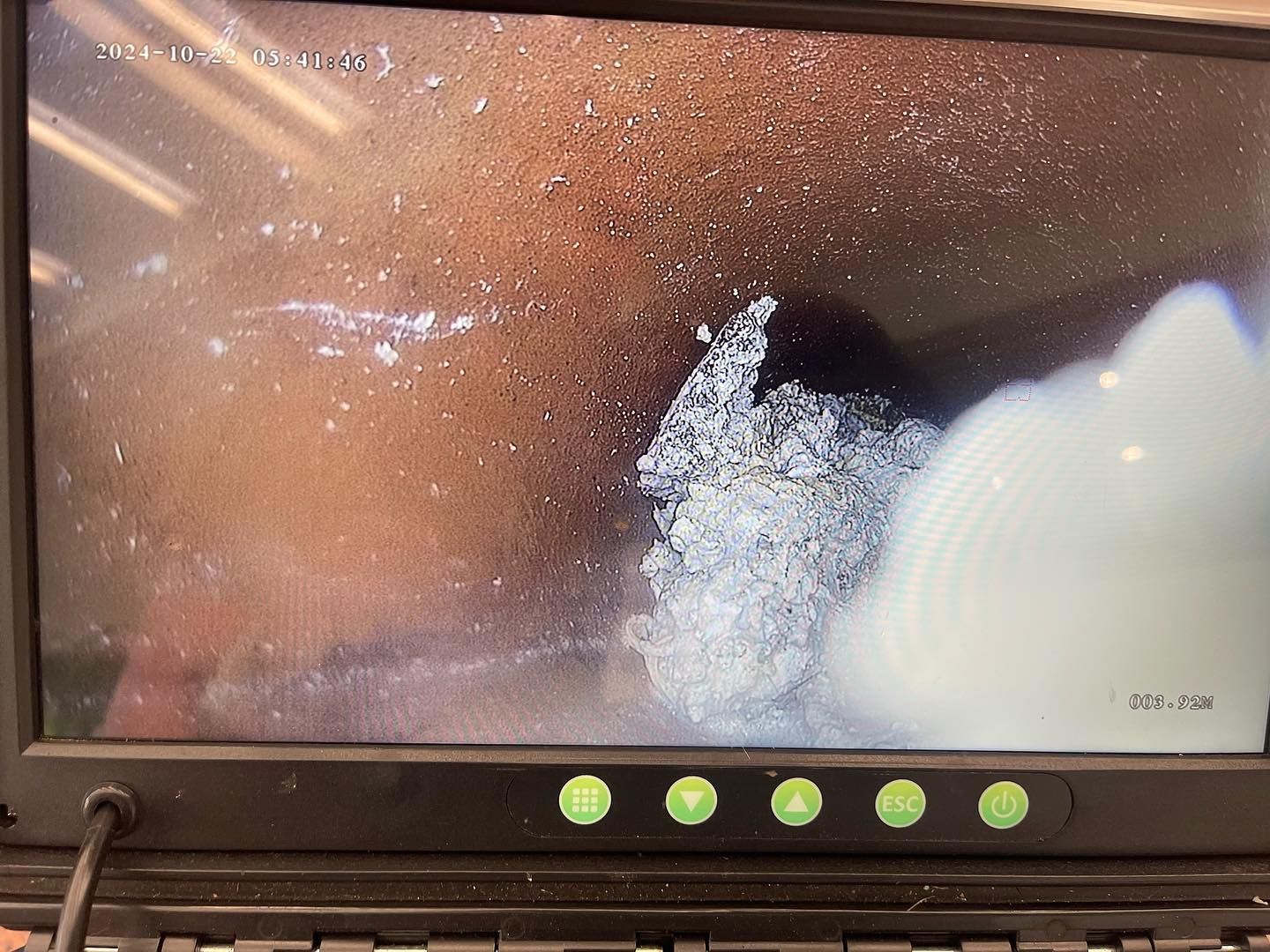 Close-up of a monitor showing a bright white rock or mineral against a brown background