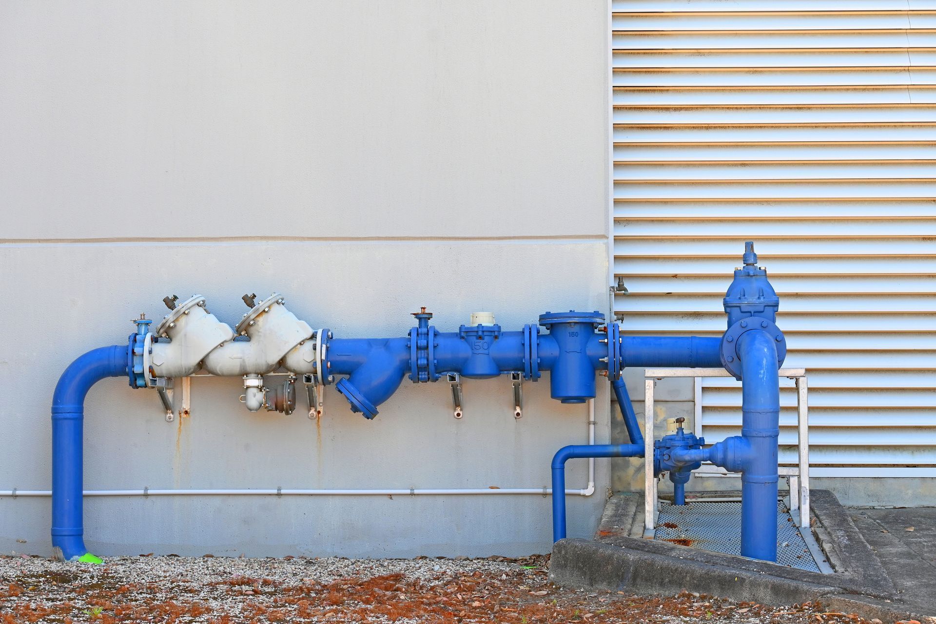 Brass plumbing fittings and white pipes arranged on technical blueprints.