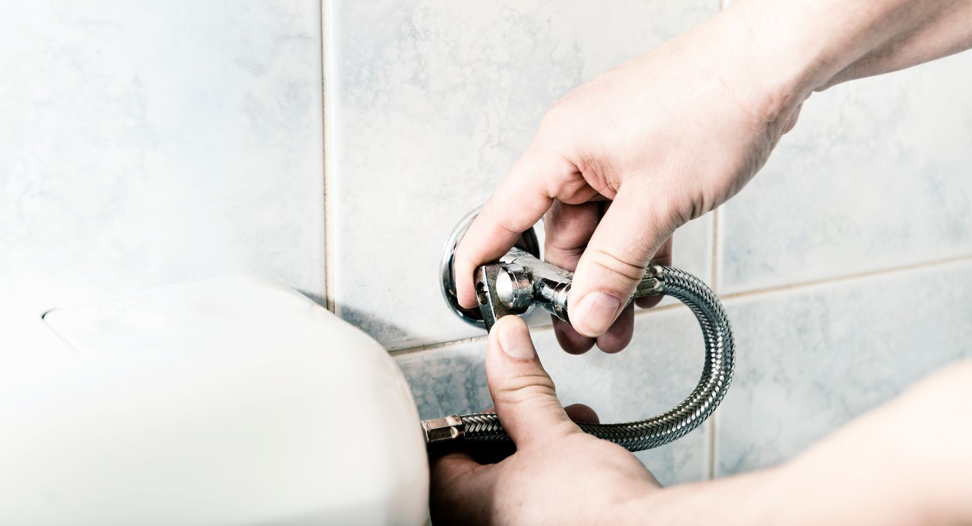 Close-up of a laboratory sink with connected white and blue tubing and flowing water