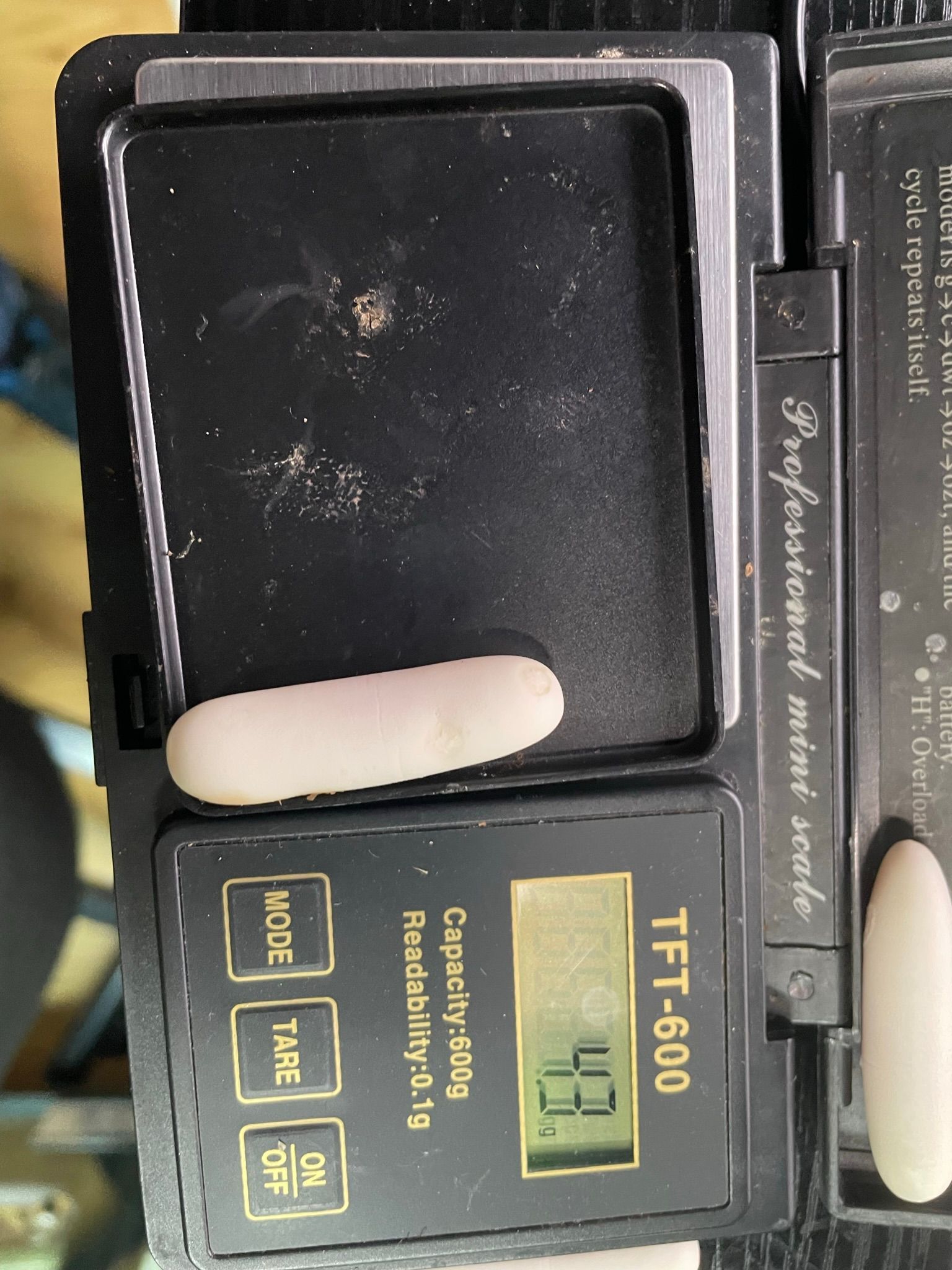 Nahaufnahme einer digitalen Küchenwaage mit einem weißen Objekt auf der Wiegeplattform, das 45 Gramm wiegt.