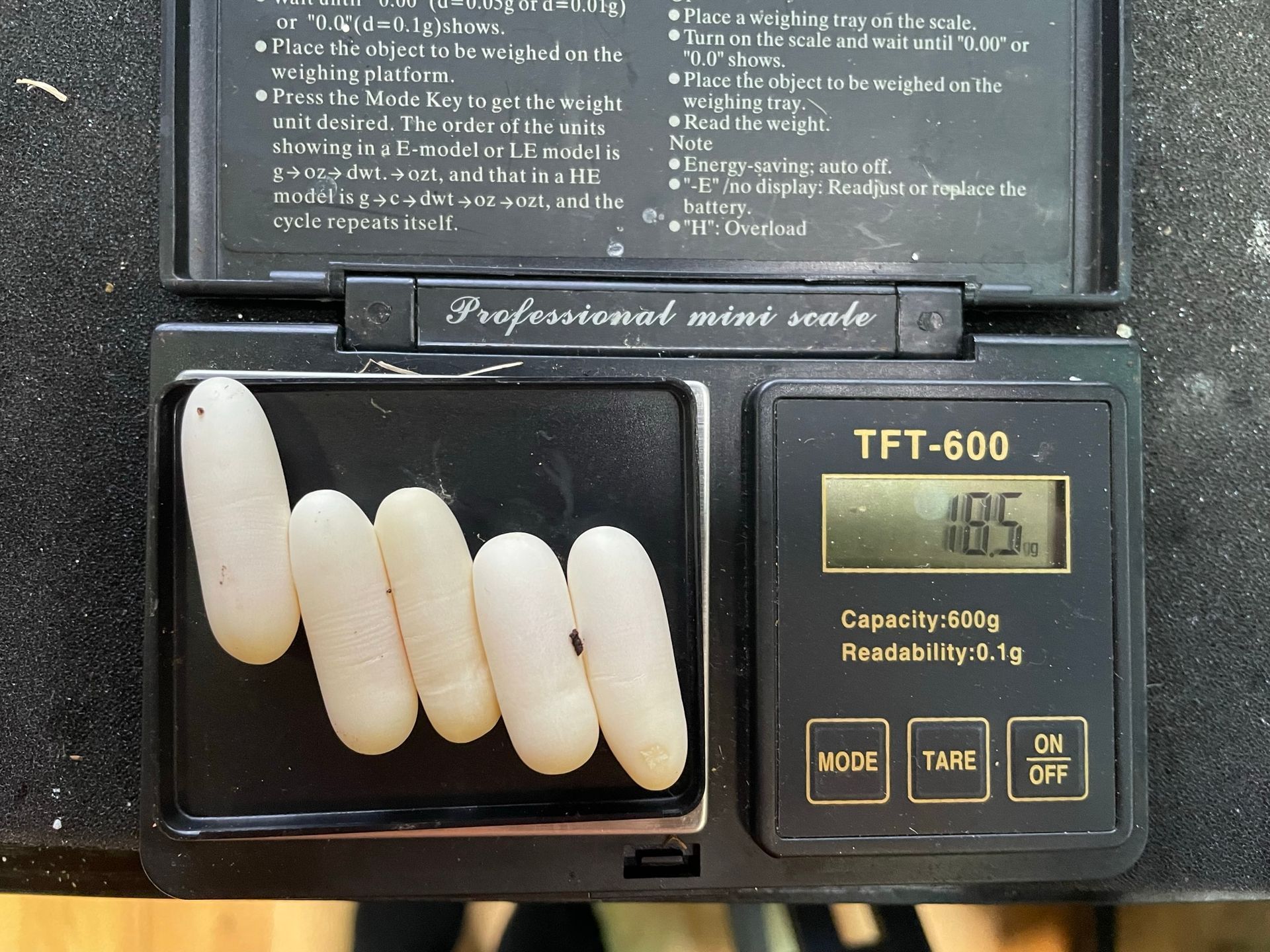 Eine Hand hält einen kleinen weißen spiralförmigen Gegenstand neben einem digitalen Display, das 86,2 °F anzeigt.