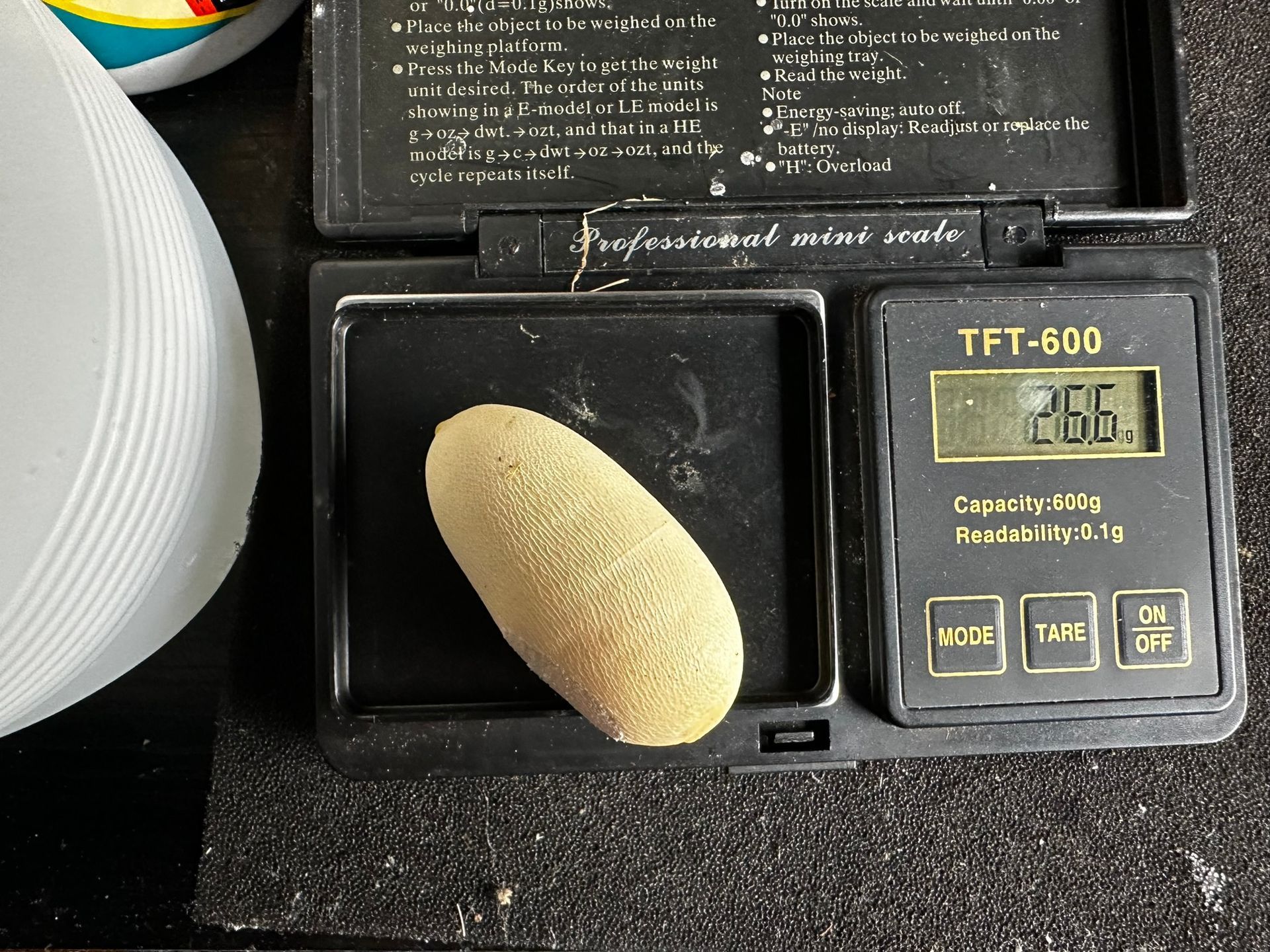 Nahaufnahme eines schwarzen elektronischen Geräts mit einem brotlaibähnlichen Objekt auf dem Tablett und einem kleinen digitalen Display.
