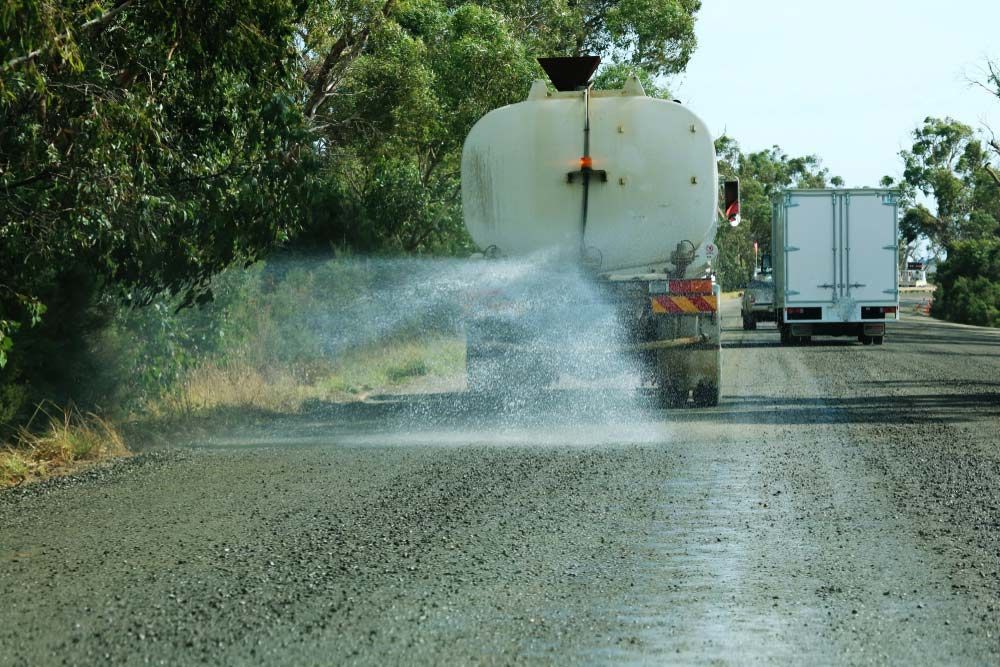 Truck Spraying Water on a Dusty Road, Reducing Dust — Keyeng in Slade Point, QLD