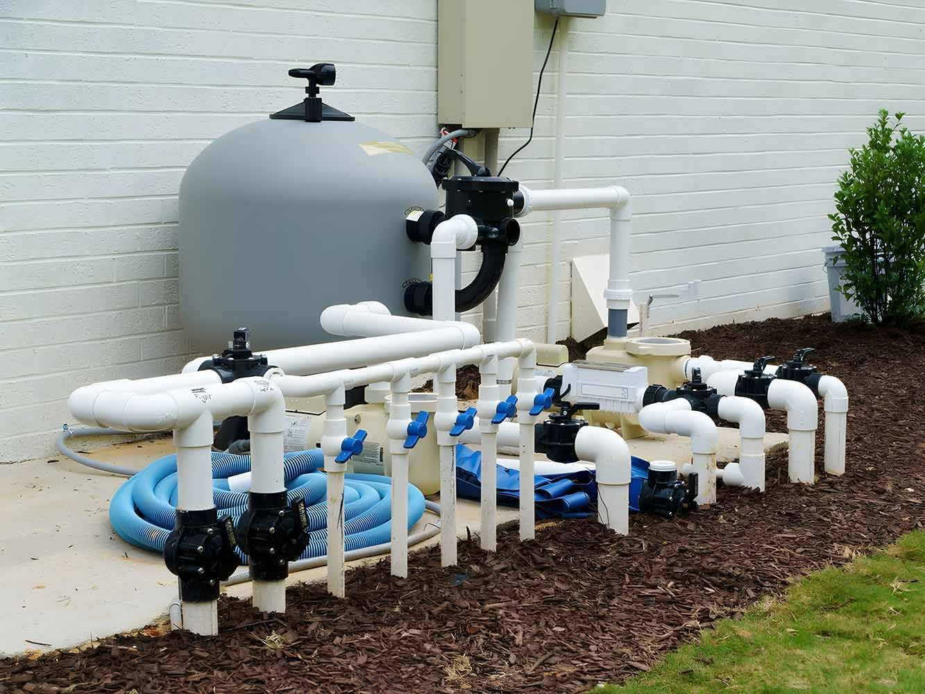 A Gray Filter Tank, White Pipes, and Black Valves on a Concrete Pad — Keyeng in Slade Point, QLD