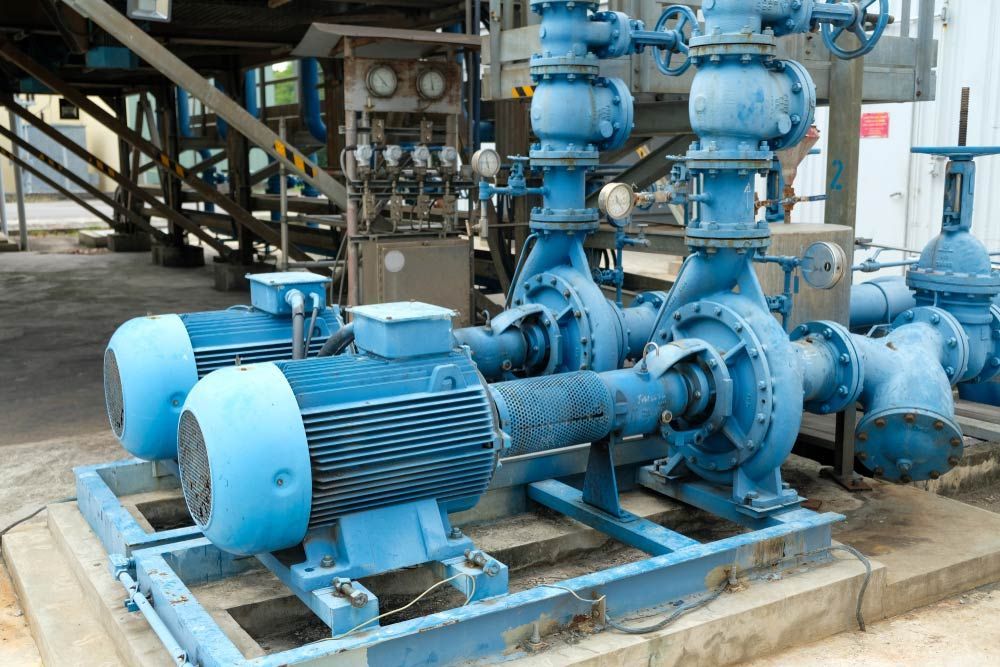 Blue Industrial Water Pumps With Motors, Pipes, and Gauges, Outdoors — Keyeng in Slade Point, QLD