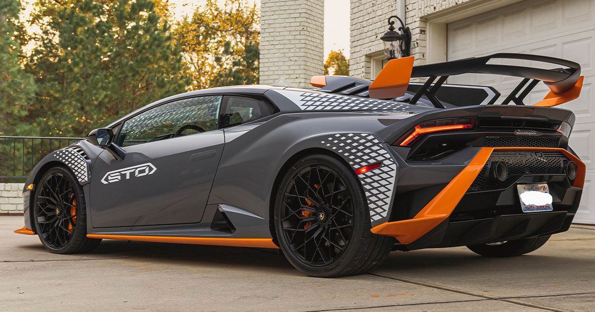 Gray Lamborghini Huracan with black and orange accents, parked outside a building.