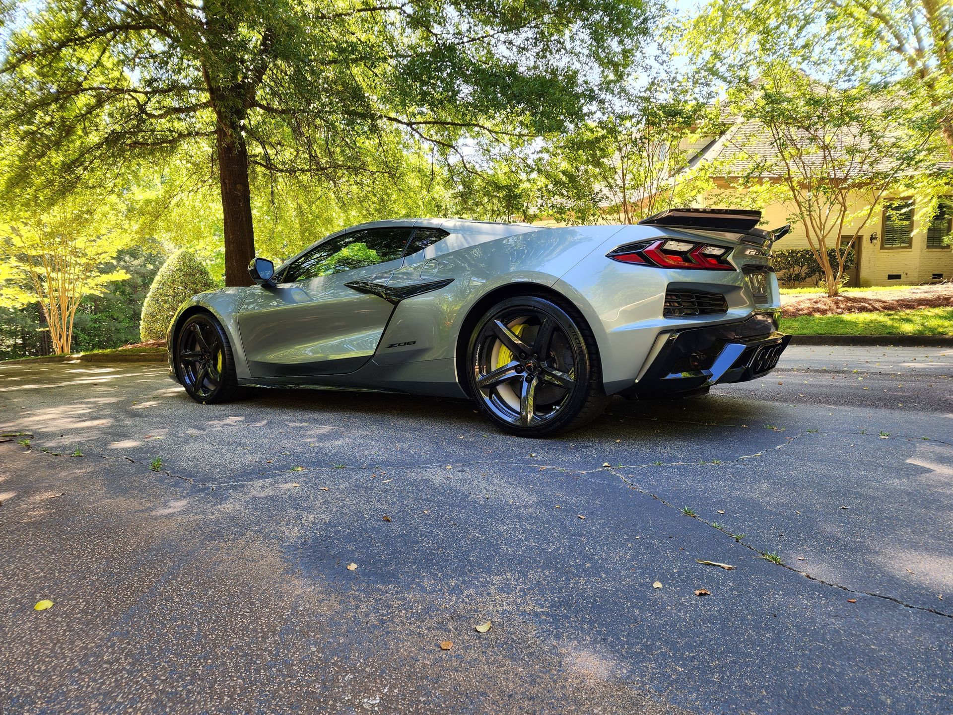 Silver sports car parked on a tree-lined street in daylight