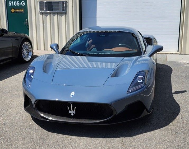 Blue Maserati sports car parked outside a building