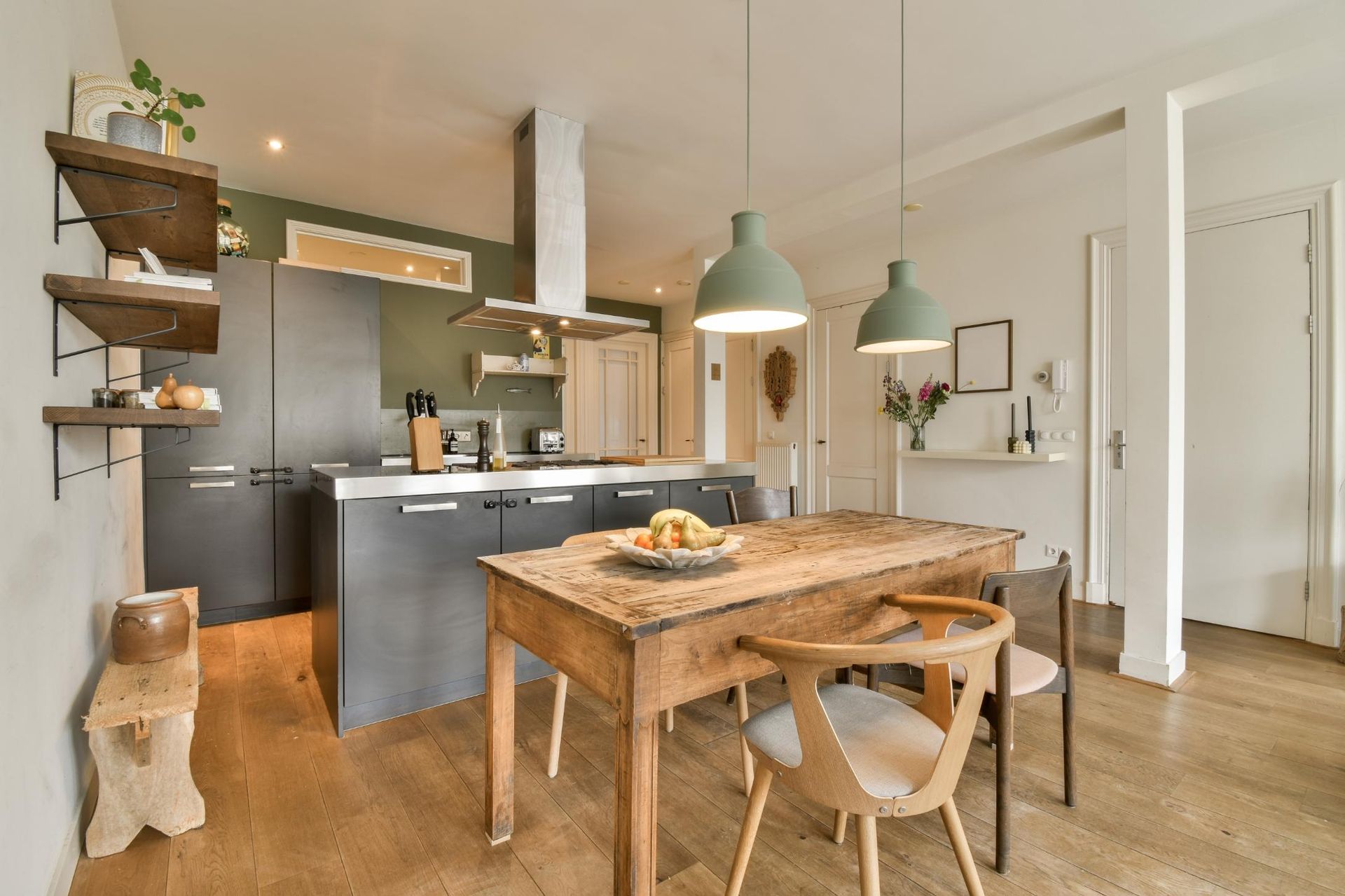 A kitchen with a wooden table and chairs in it.