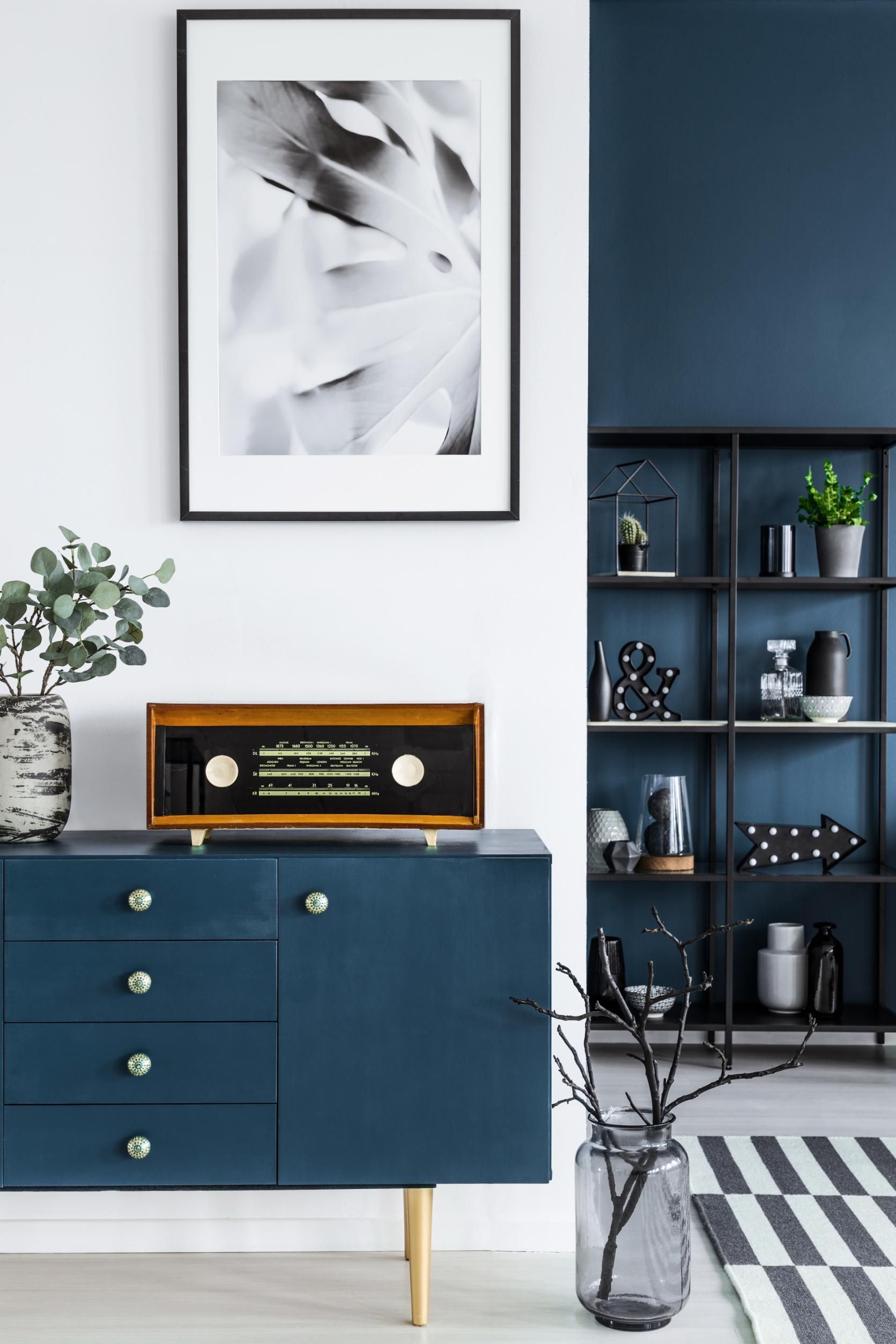 A blue dresser with a radio on top of it in a living room.