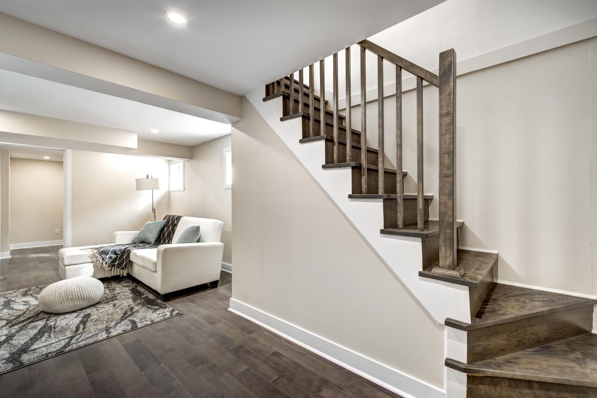 A living room with a staircase leading up to the second floor.