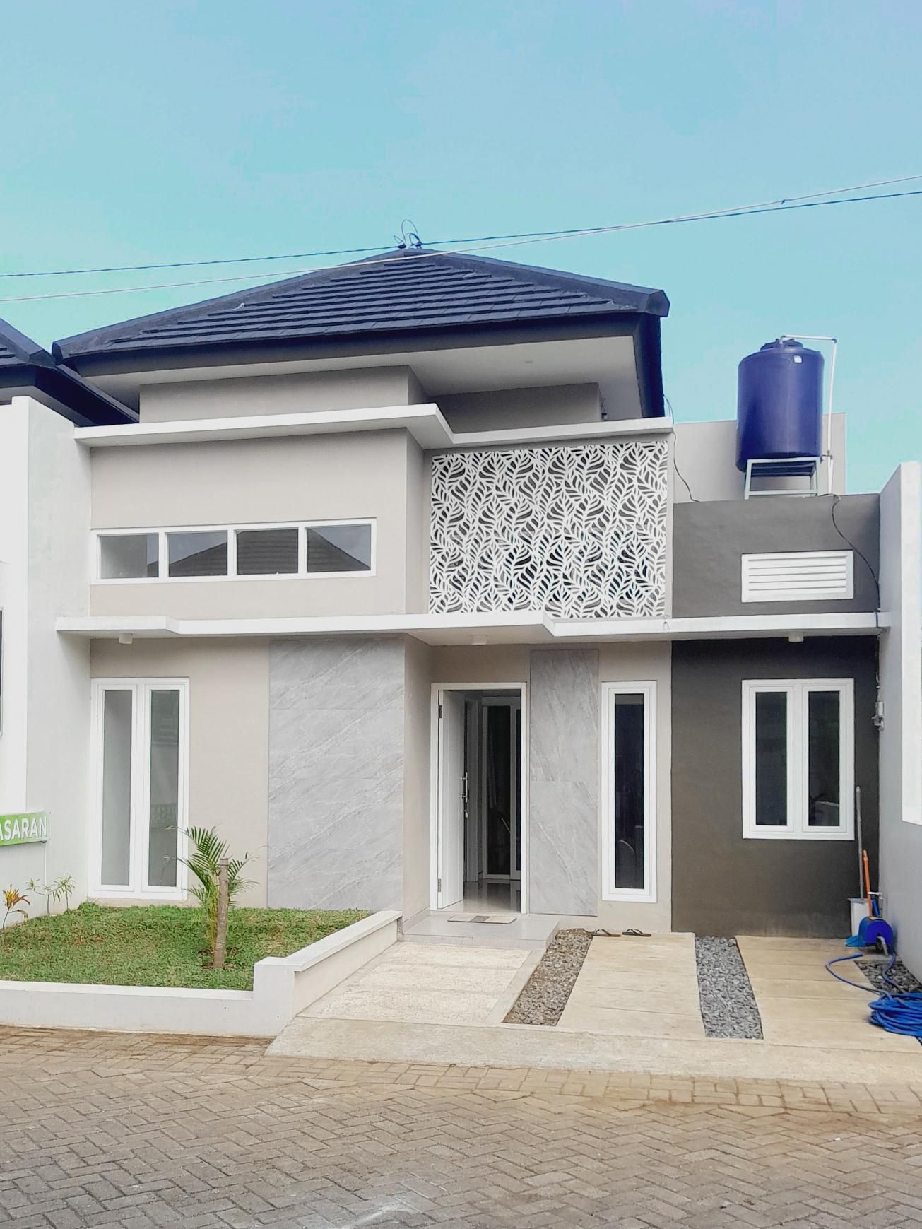 The front of a house with a blue water tank on the roof.