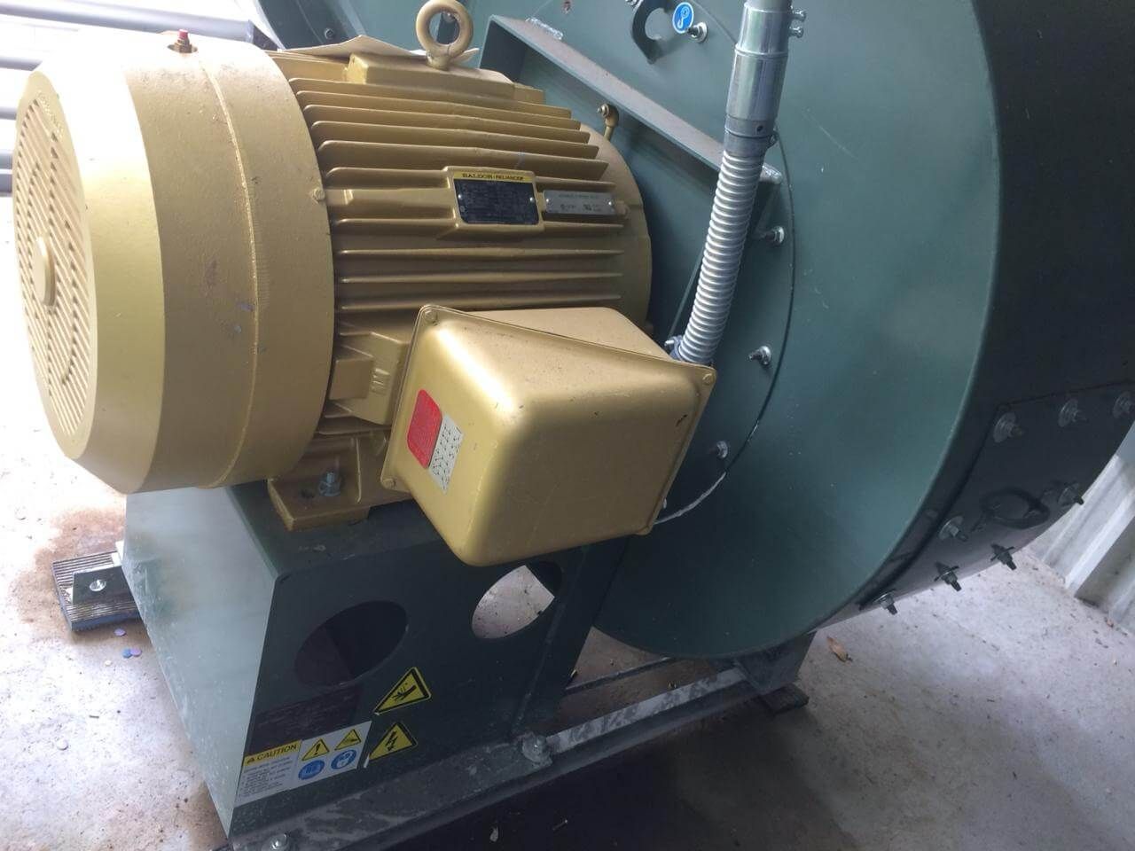 Motor dorado conectado a una máquina verde, probablemente equipo industrial, con cableado visible.