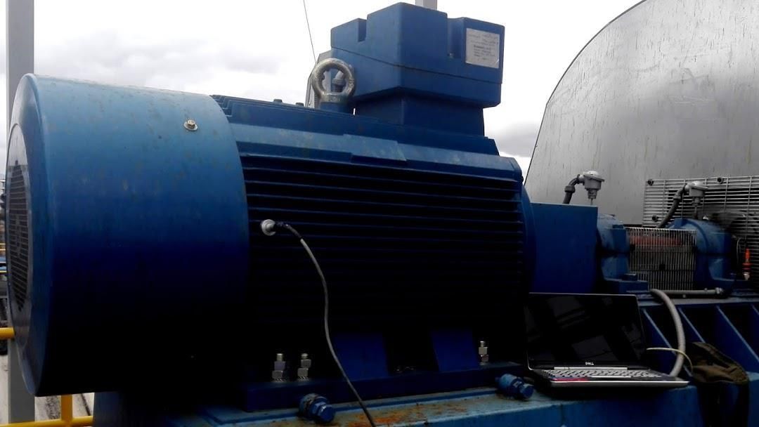 Motor industrial azul con ventilaciones negras, montado en exterior sobre plataforma azul.