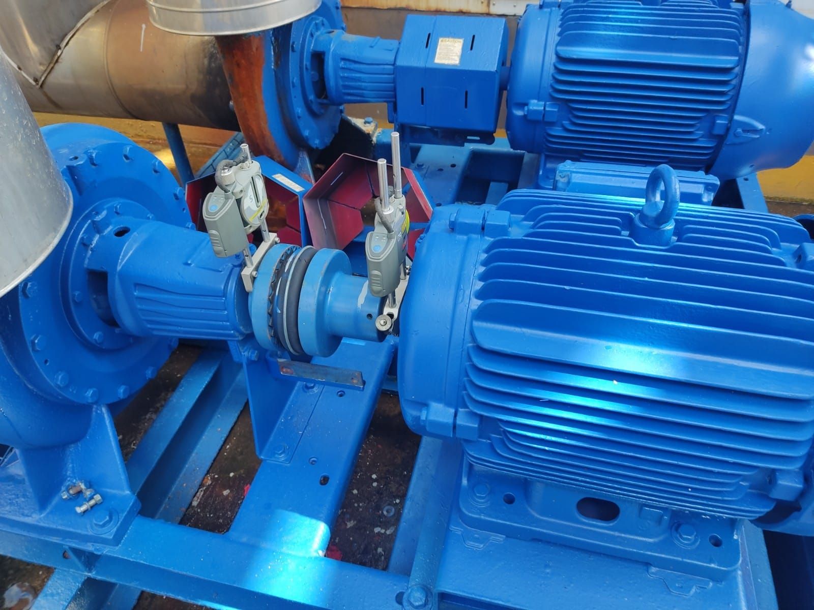Maquinaria industrial azul con motores y acoplamientos conectados, montada sobre un marco azul.