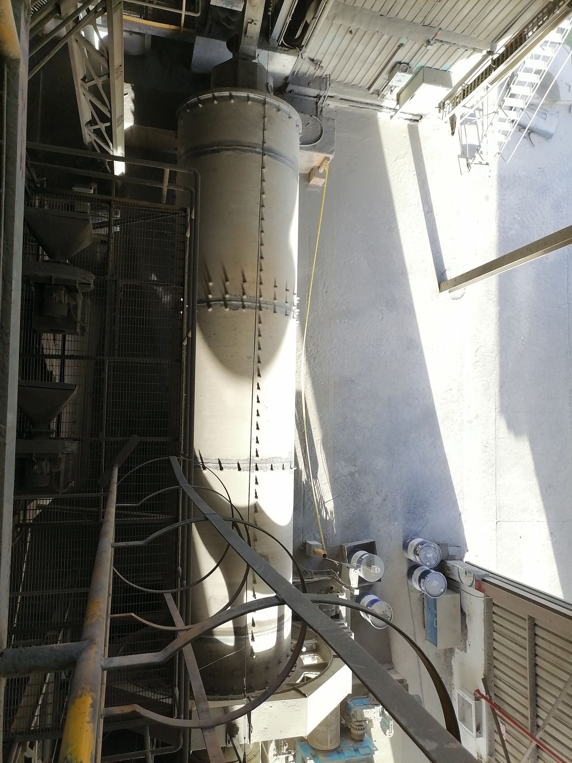 Gran silo industrial con trabajadores cerca.