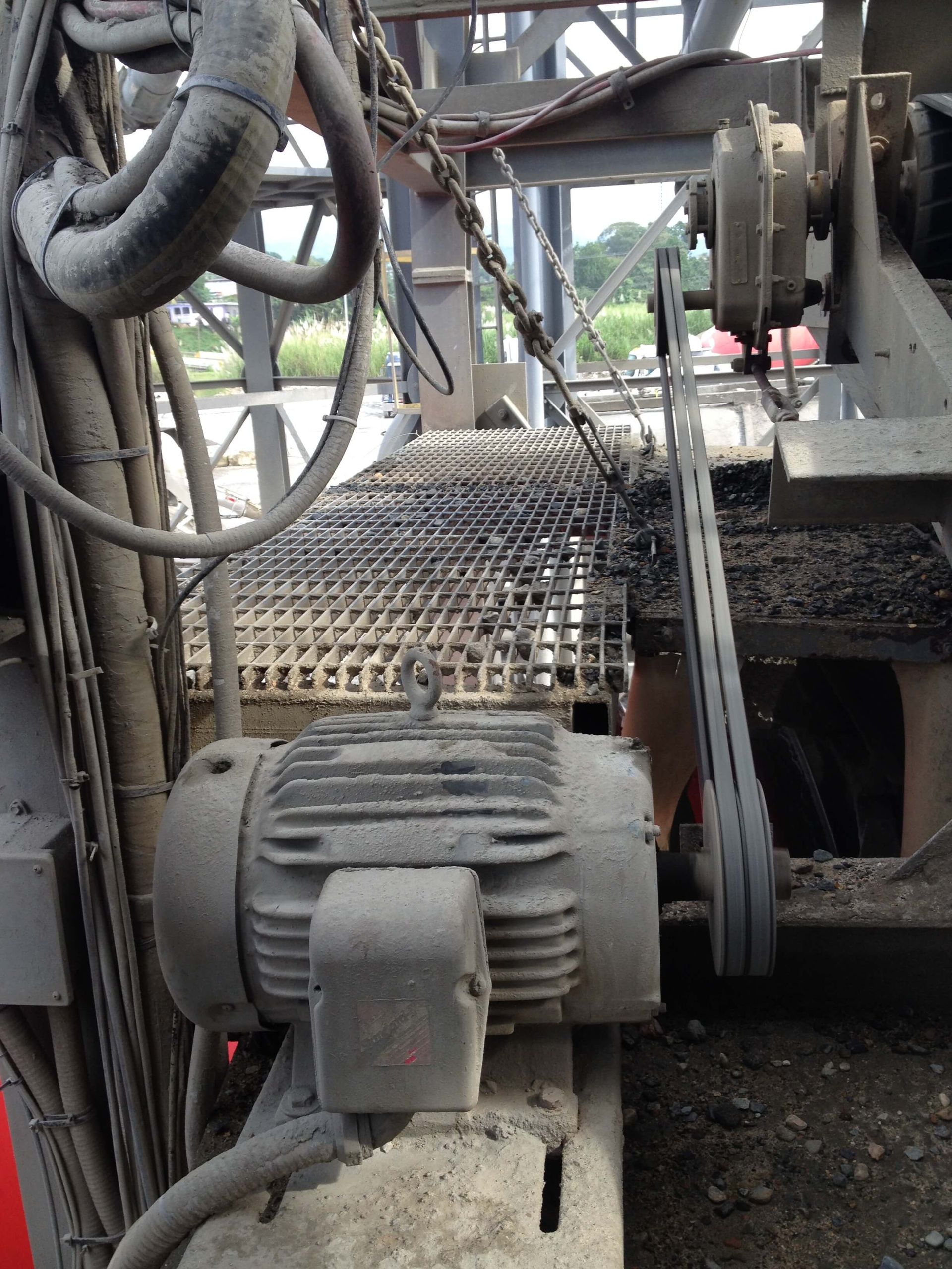 Motor eléctrico y sistema de transmisión por correa, parte de maquinaria industrial.
