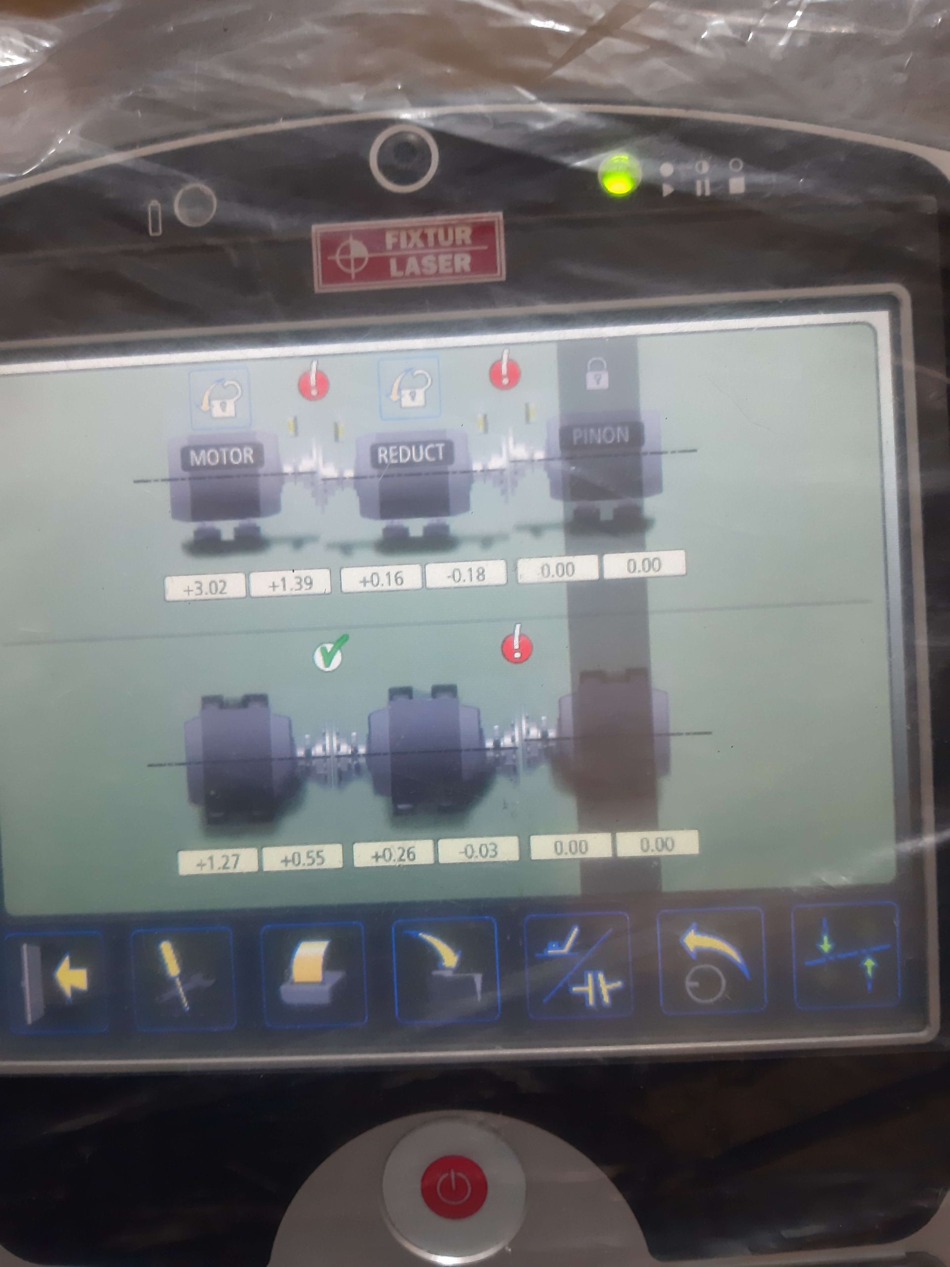 El panel de control de una máquina láser muestra mediciones y símbolos con una operación activa.