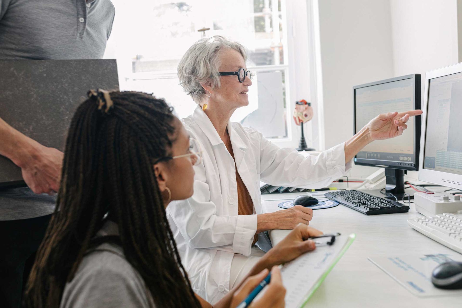 A group of people are sitting at a desk looking at a computer screen.