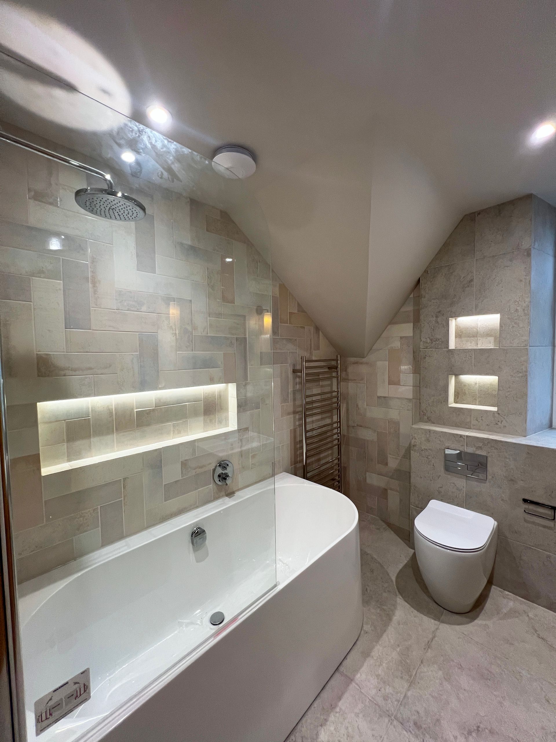 A bathroom with a bathtub , toilet and shower