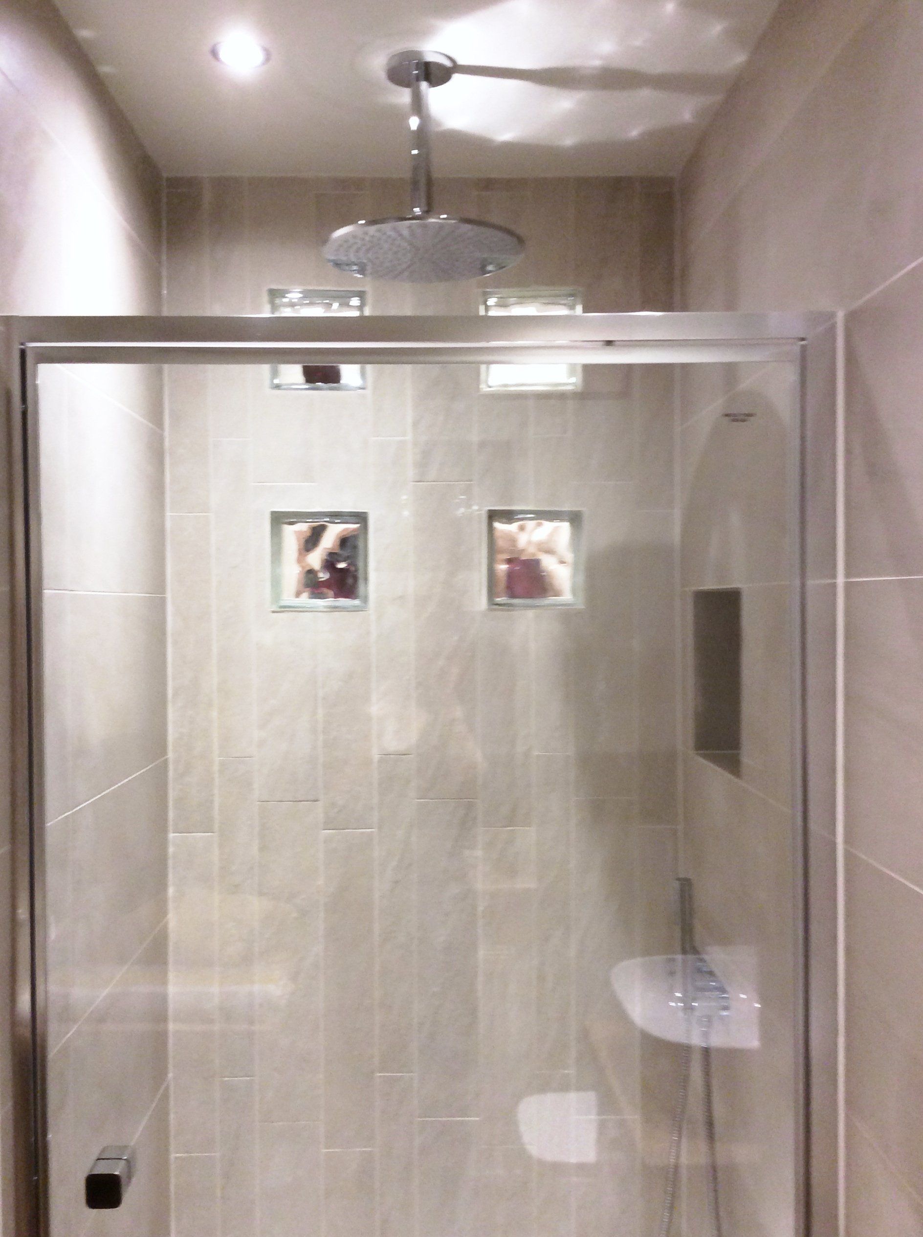 A shower with a sliding glass door and a shower head