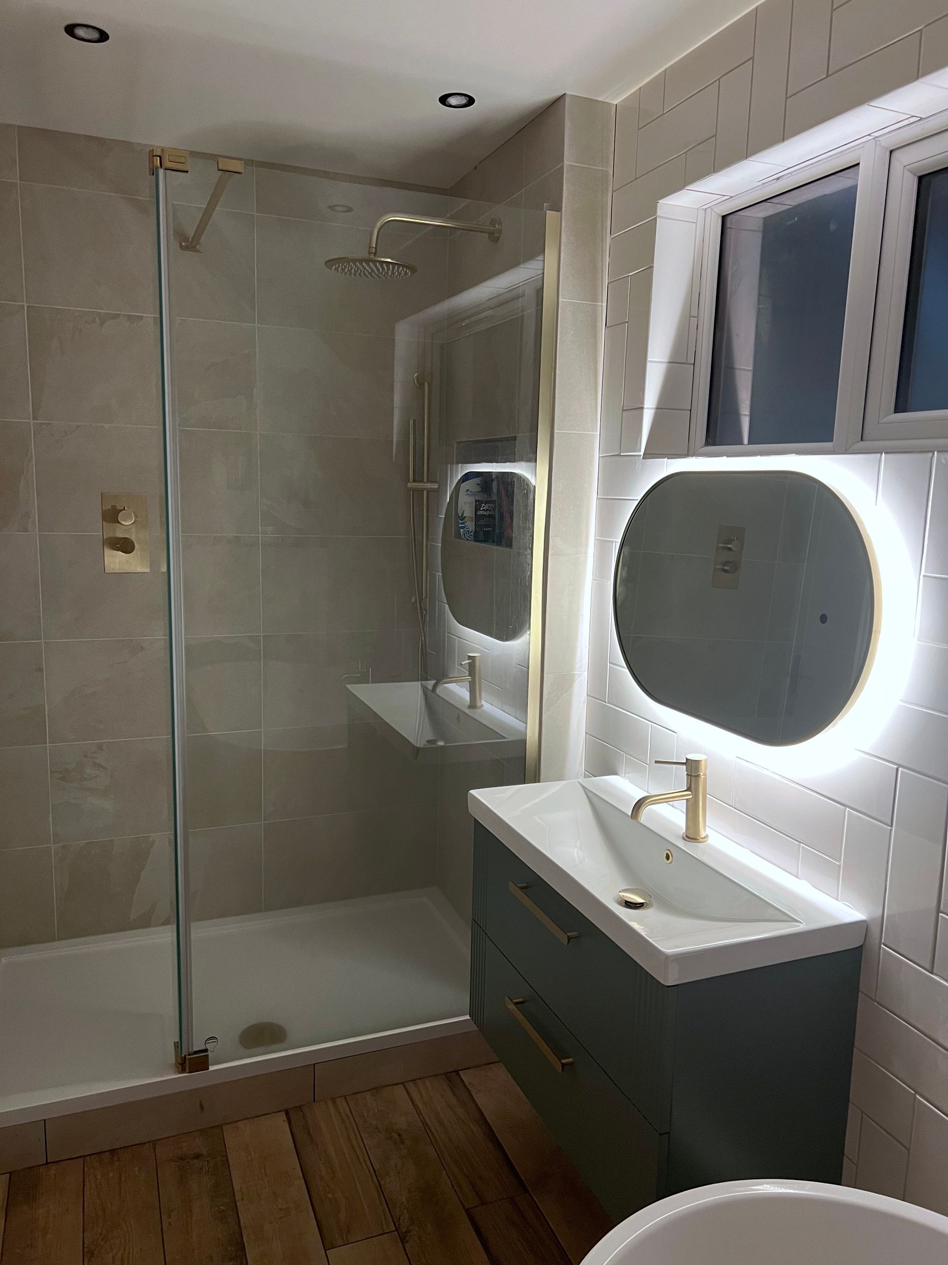 A bathroom with a sink , mirror and shower.