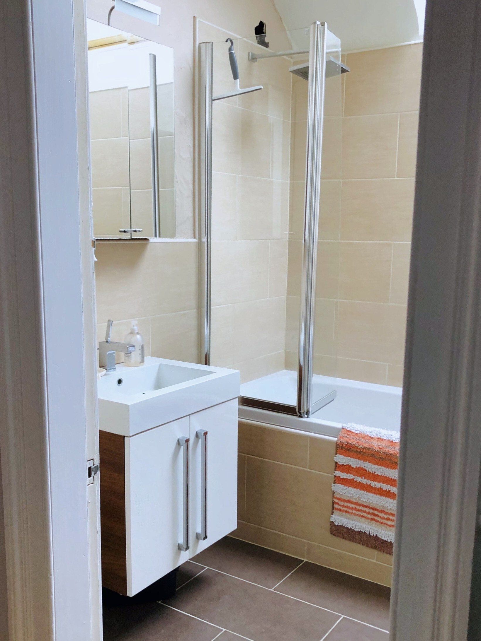 A bathroom with a sink , tub and shower.