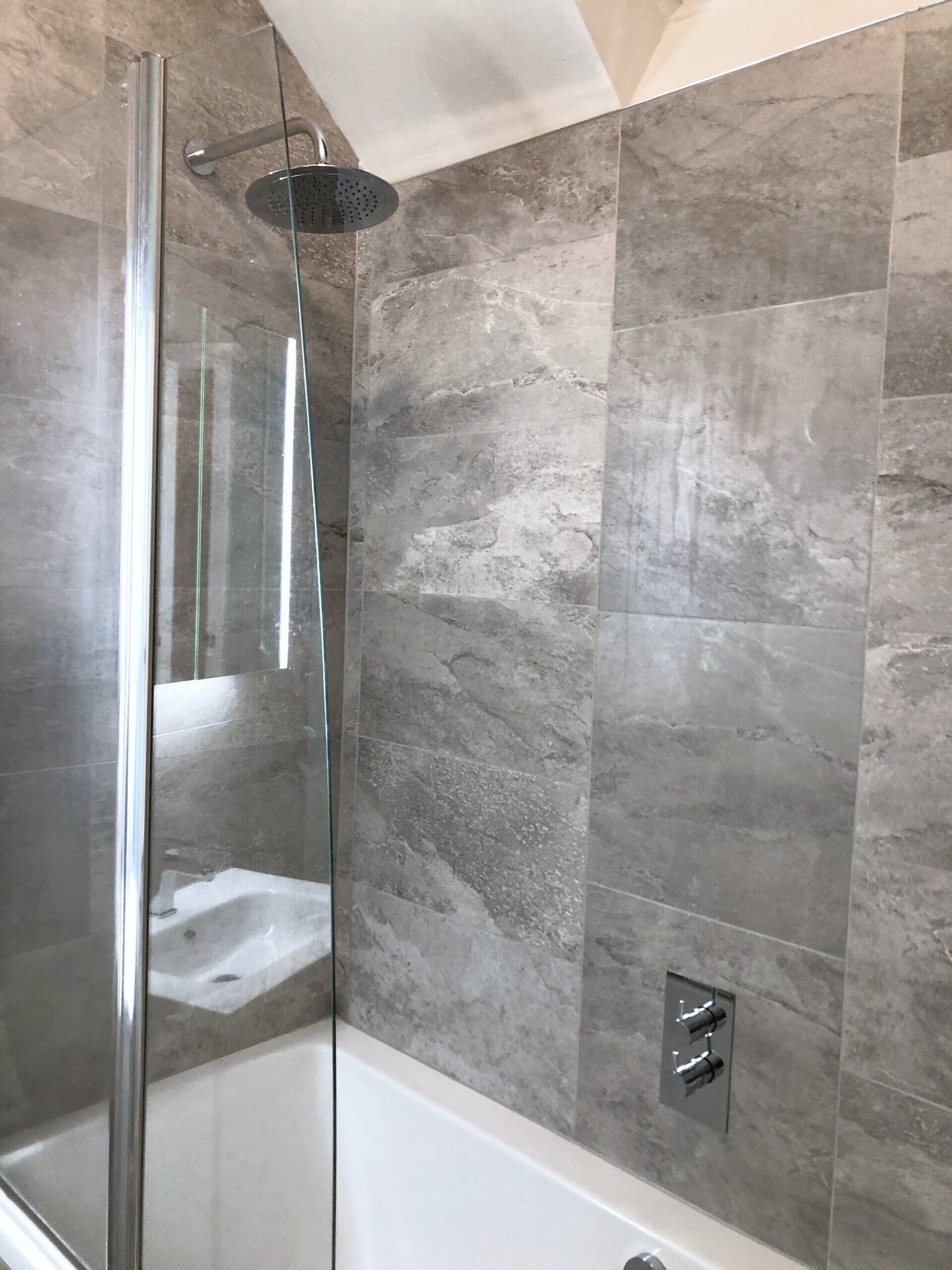 A bathroom with a shower and a bathtub.