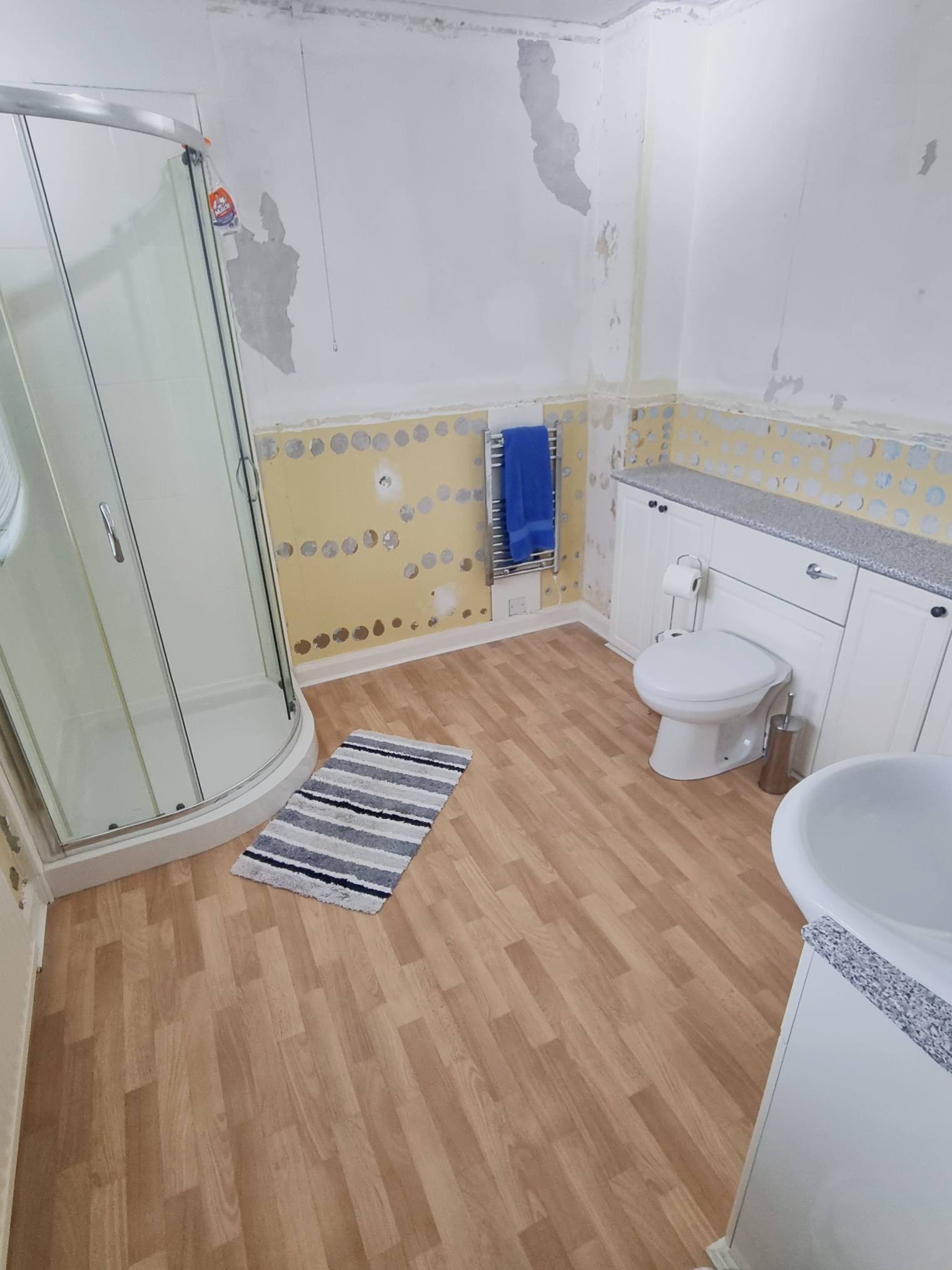 The old (before) bathroom with a toilet, sink and shower cabin.