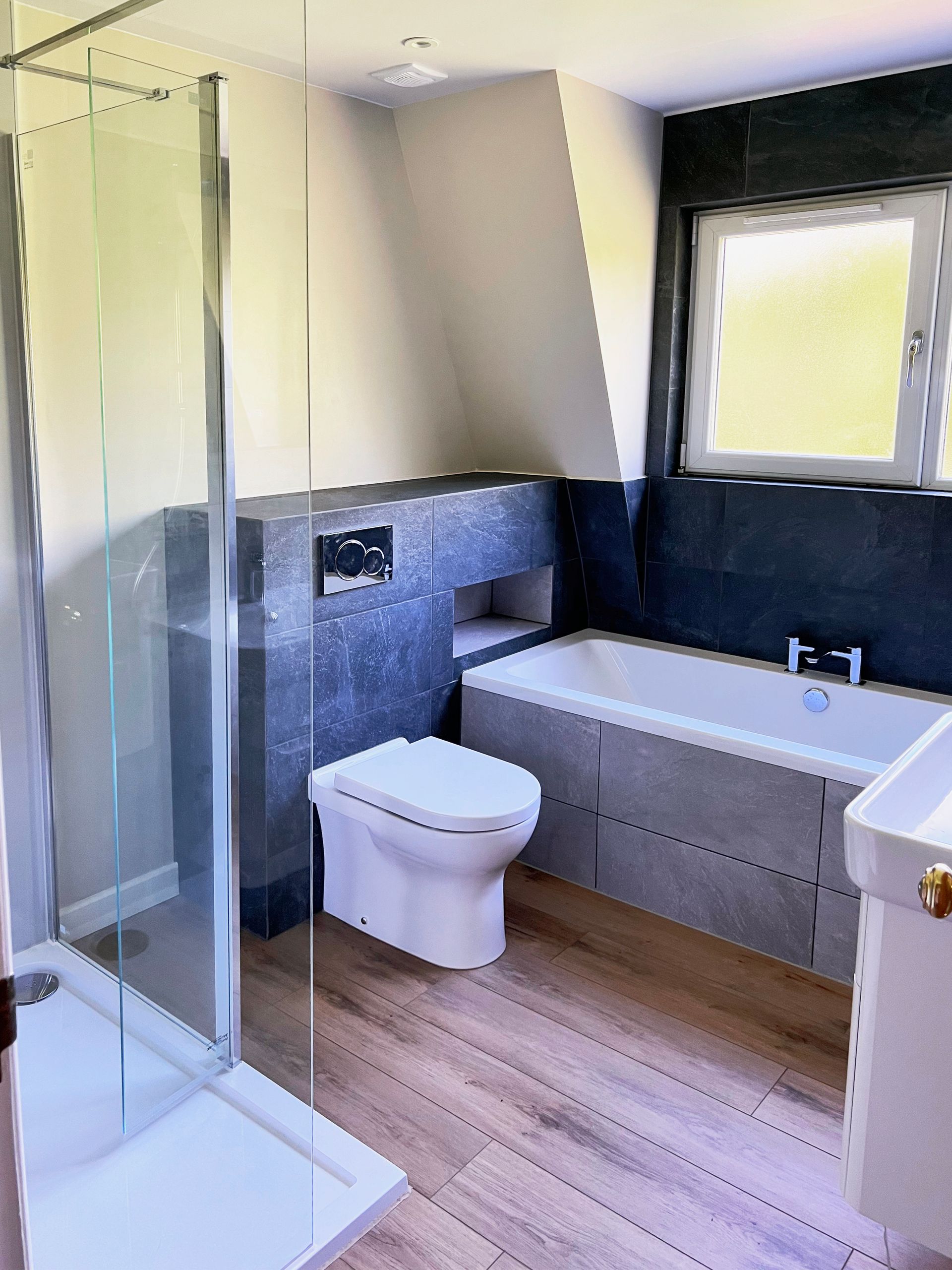 A bathroom with a toilet , bathtub , sink and shower.