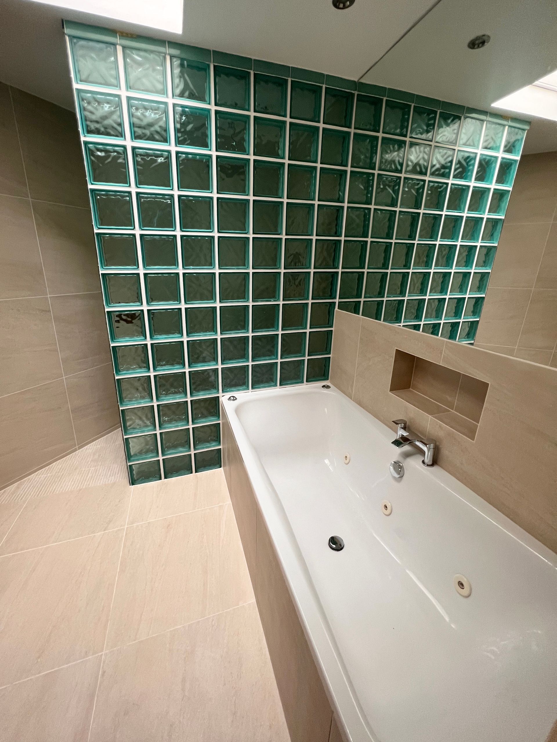 A bathroom with a bathtub and a glass block wall