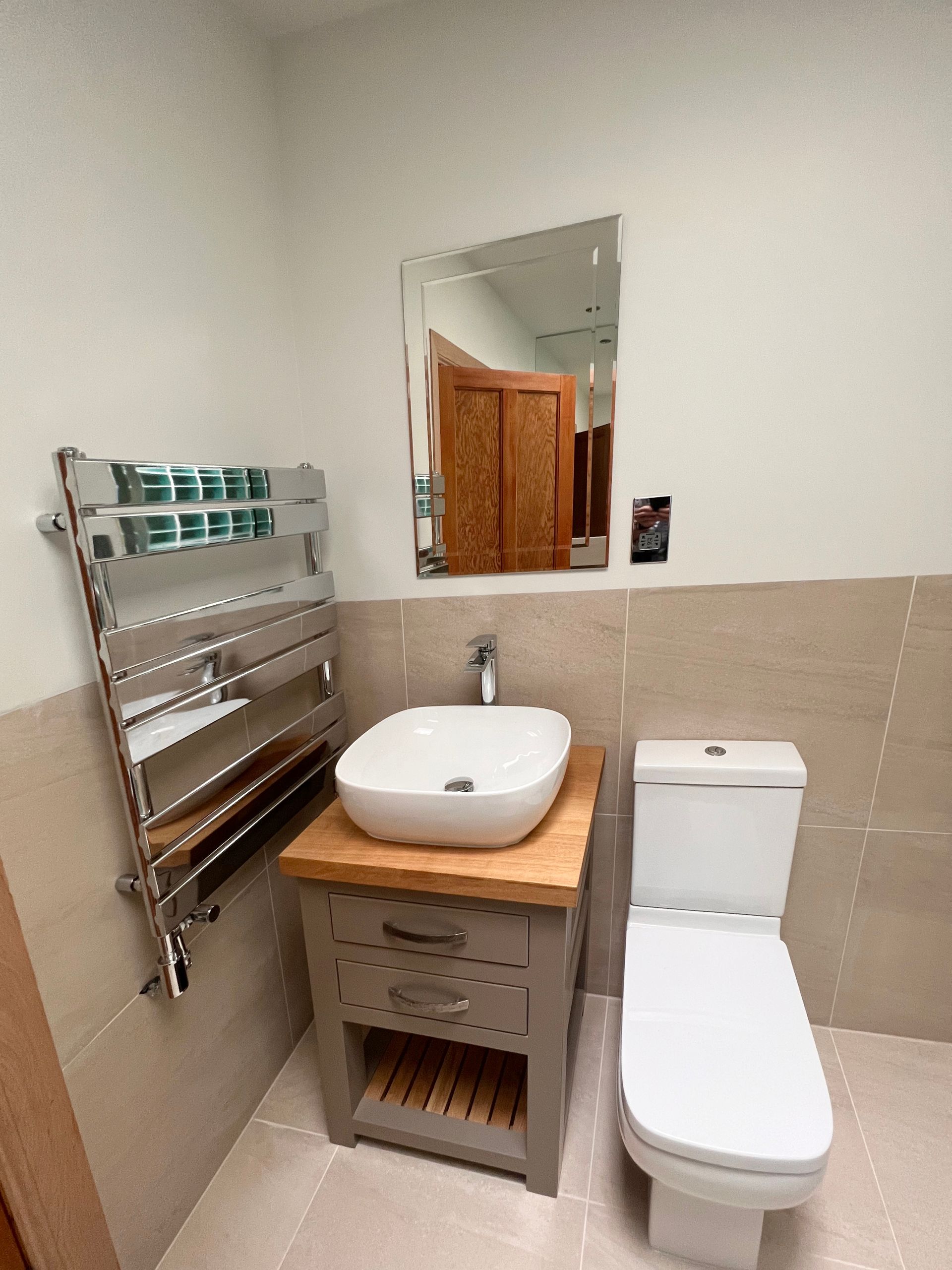 A bathroom with a toilet , sink and mirror.