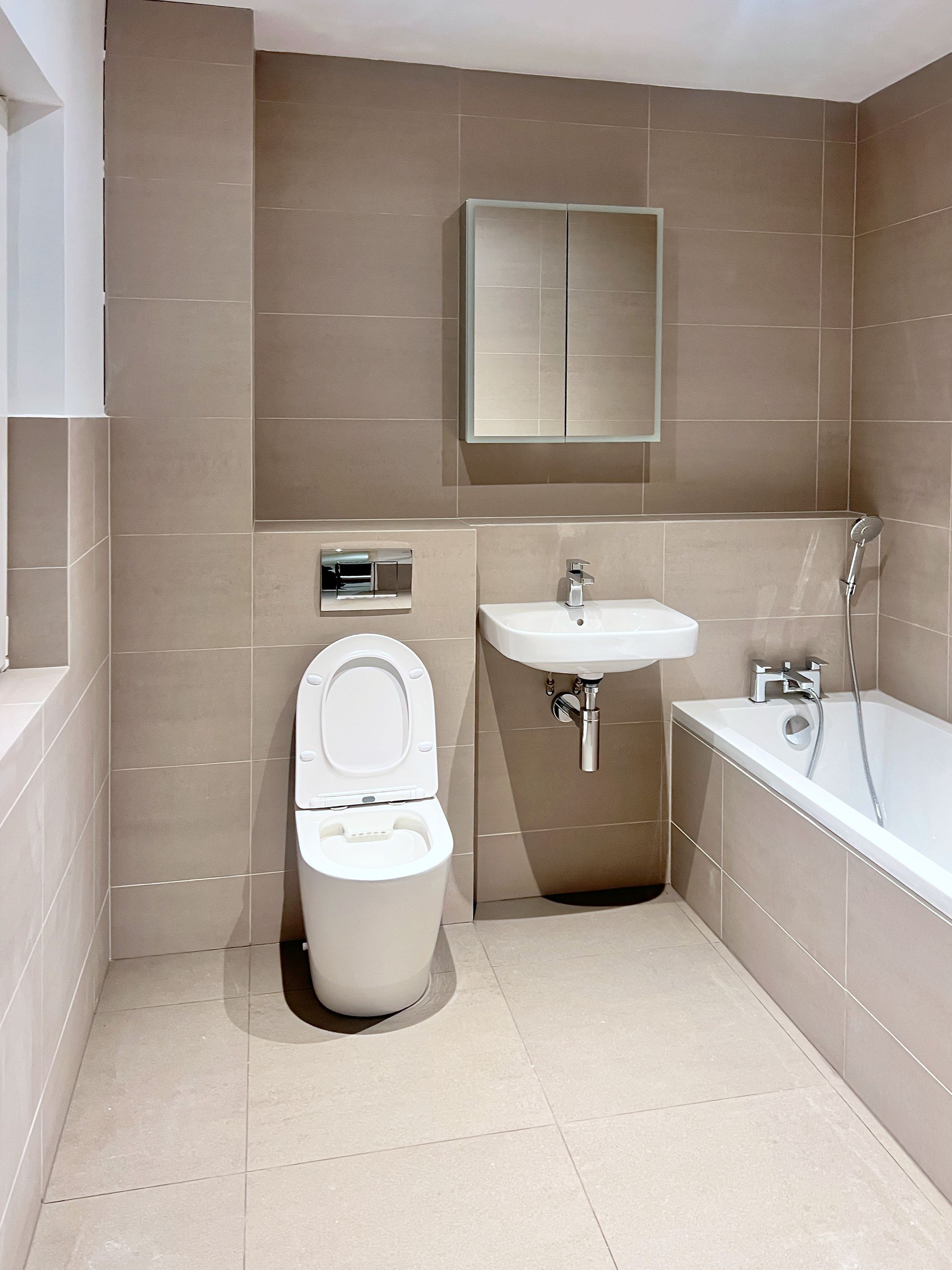 A bathroom with a toilet a sink and a bathtub