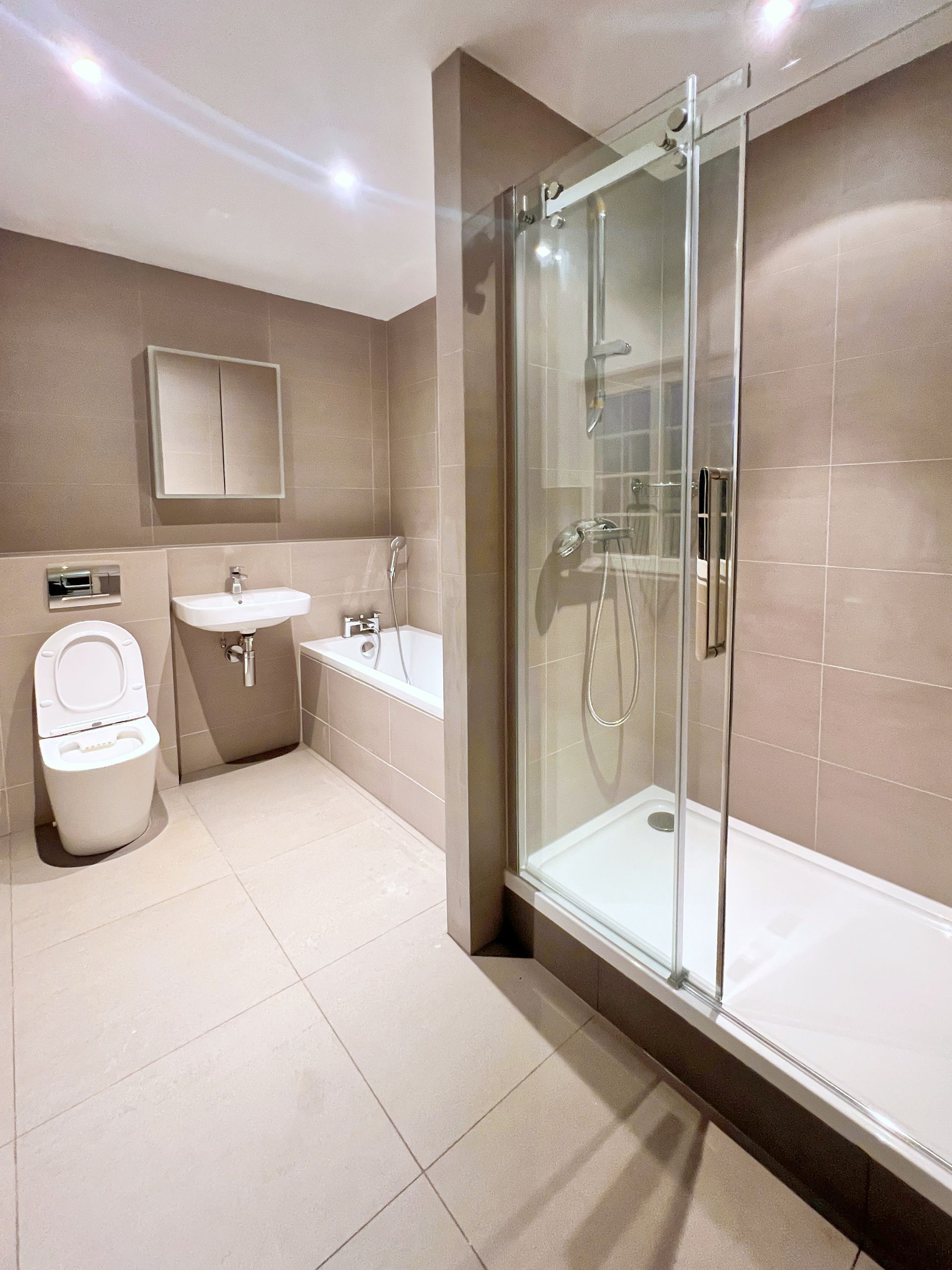 A bathroom with a toilet , sink , tub and shower