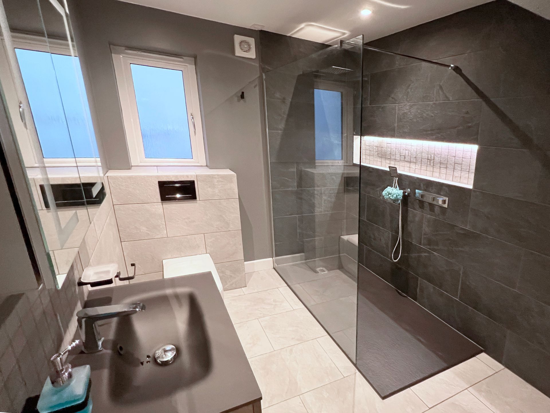 A bathroom with a sink, toilet and walk in shower.